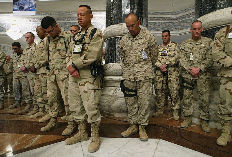 Soldiers pause for a moment of silence during a Memorial Day ceremony in Iraq in 2004
