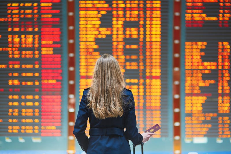 Traveler looking for their flight on a flight board with cancellations.
