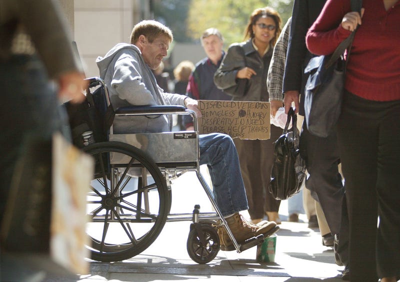 A homeless, disabled veteran in his wheelchair is surrounded by pedestrians as he is looking for money along the shopping area known as the "Magnificent Mile" on Michigan Ave. September 30, 2004 in Chicago.