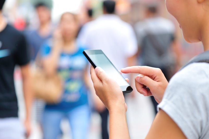 A woman uses her smartphone in a crowd