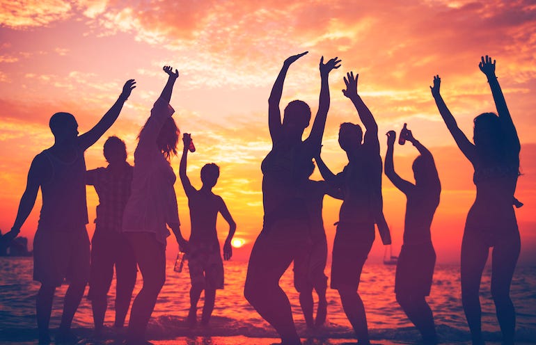 People partying on beach during sunset
