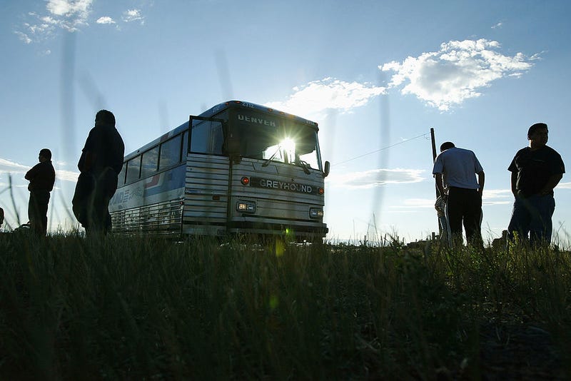Passengers stand on the roadside during a short Greyhound bus layover in Wyoming