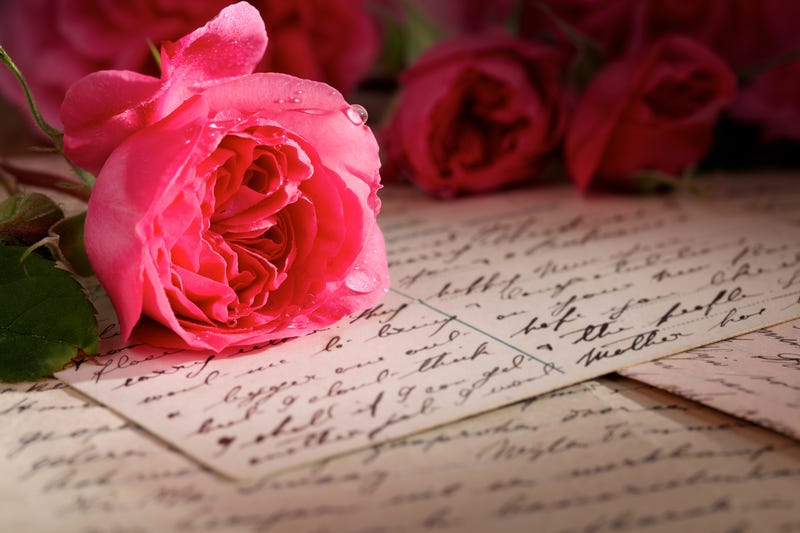 A bunch of roses lies on top of hand written notes