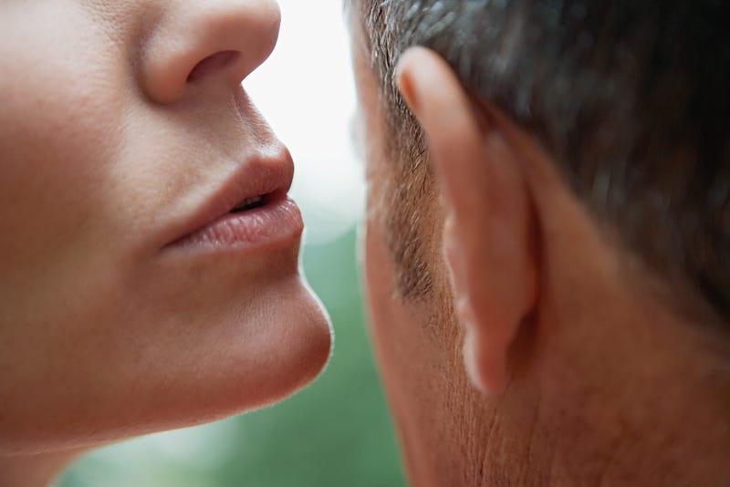 Woman whispering into a man's ear