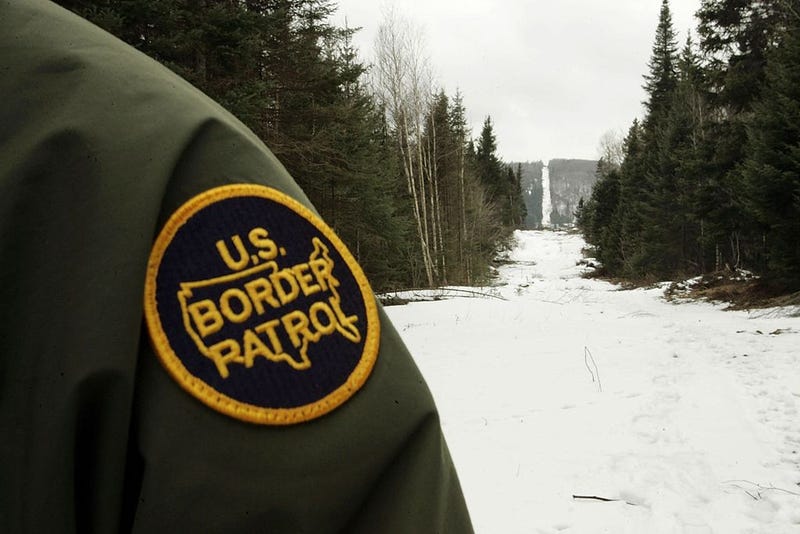 A U.S. Border Patrol agent stands along the boundary marker cut into the forest marking the line between Canadian territory on the right and the United States March 23, 2006 near Beecher Falls, Vermont. As American politicians continue to debate immigration reform, Border Patrol agents work the northern border to prevent illegal entry.