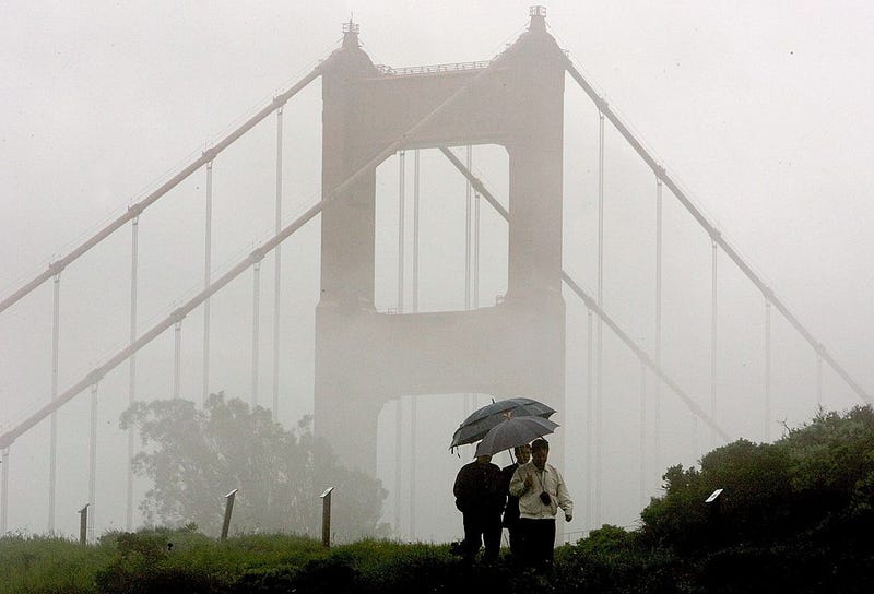A group of men walk through the rain near the north tower of the Golden Gate Bridge April 12, 2006 in Sausalito, California.