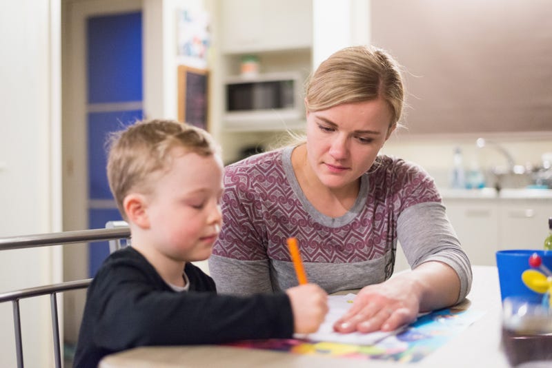 woman helps child with homework