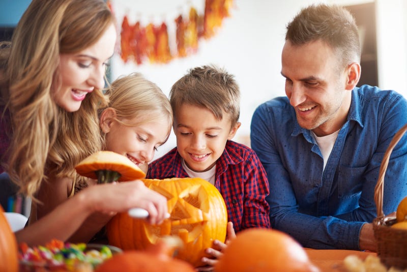family carving halloween pumpkin