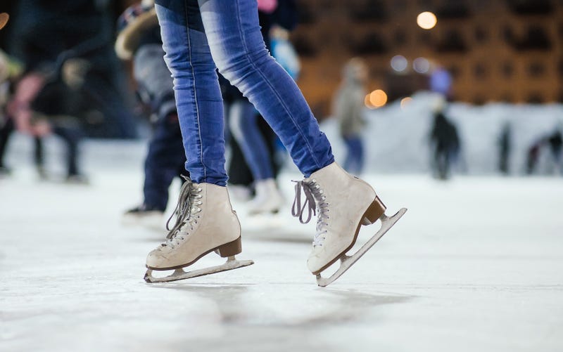 woman in ice skates standing on an ice rink
