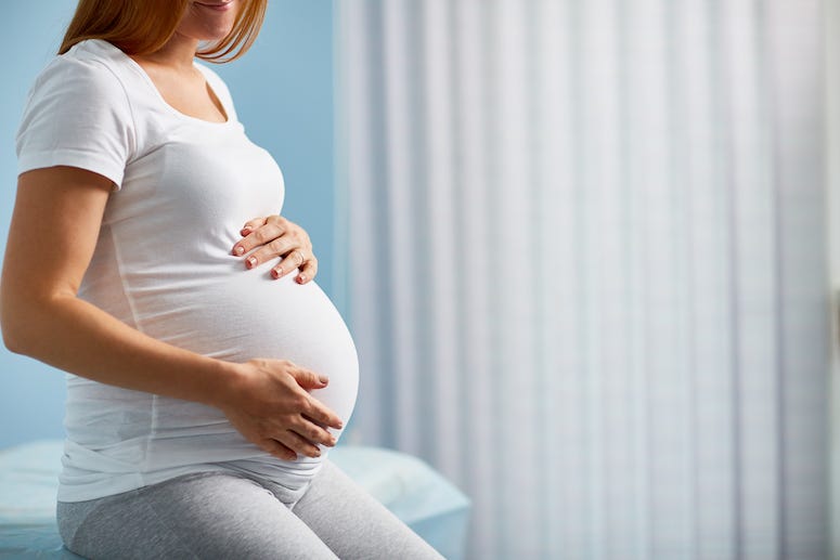Pregnant woman sitting on table