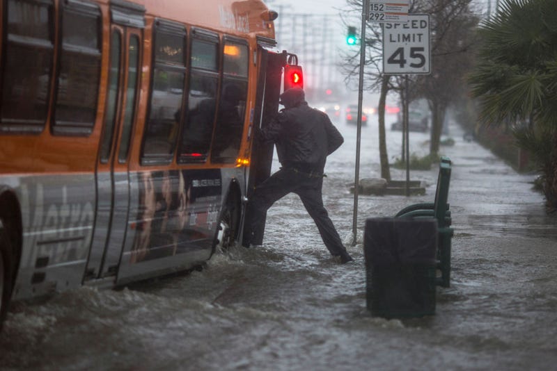 A man boards a bus on a flooded street as a powerful storm moves across Southern California on February 17, 2017 near Sun Valley, California.