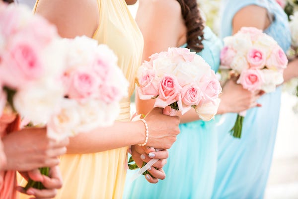 Bridesmaids holding bouquets of roses during a wedding