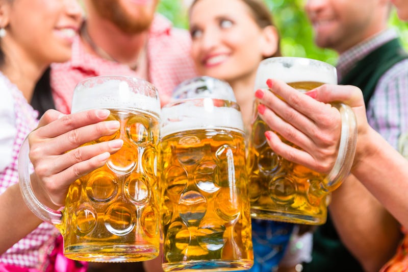 Group of friends holding steins and cheersing.