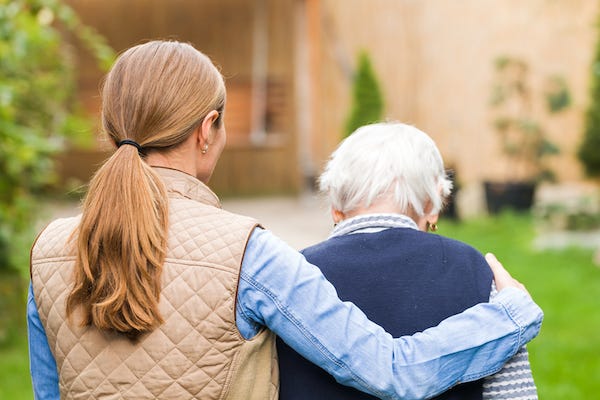 Young woman walking with older woman outdoors