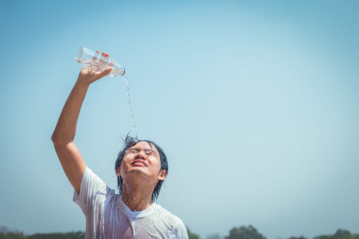 young man pouring cold water on head
