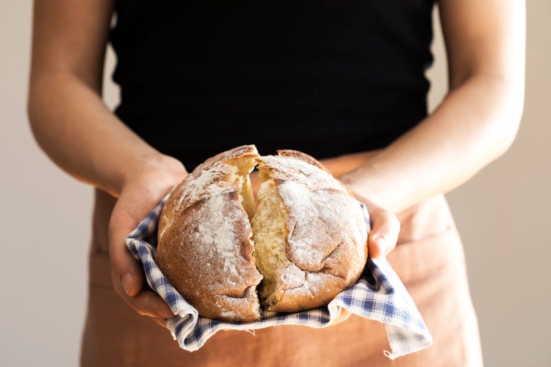 woman holding loaf of baked bread