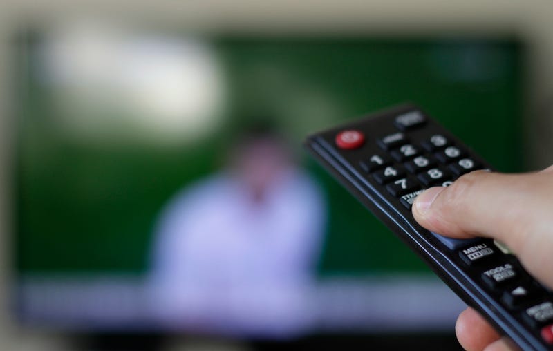 Remote control with TV set in the background