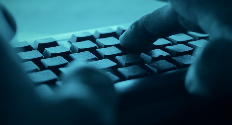 Hands typing on desktop computer keyboard.