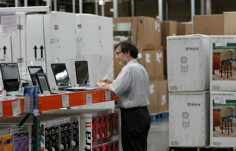 man checks out the laptops at costco