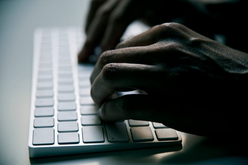 Person typing on a keyboard in the dark.
