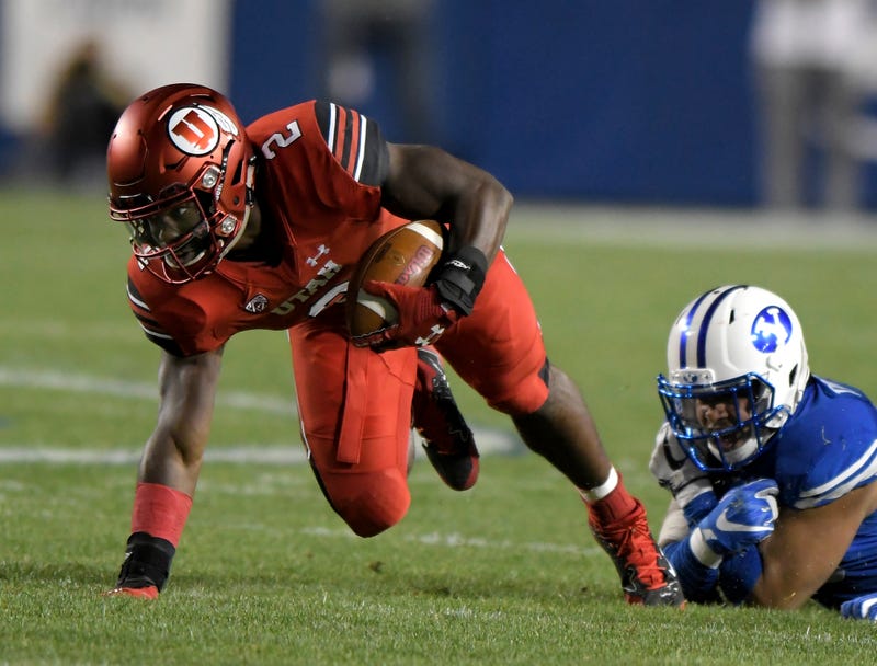Utah's Zack Moss tries to stay on his feet