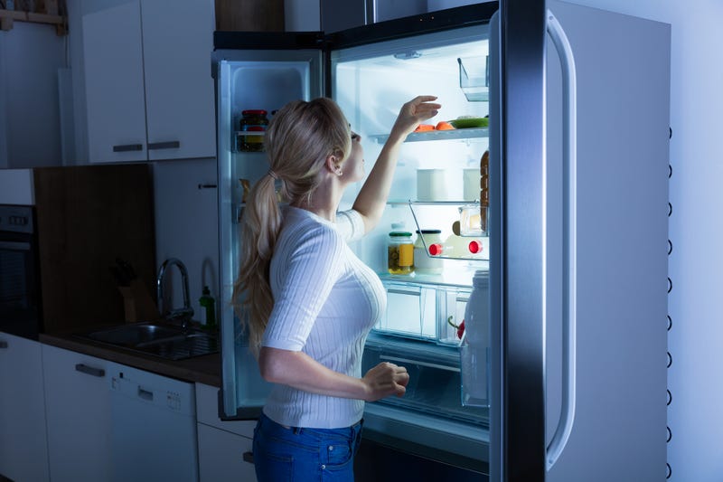 woman looking for food in fridge