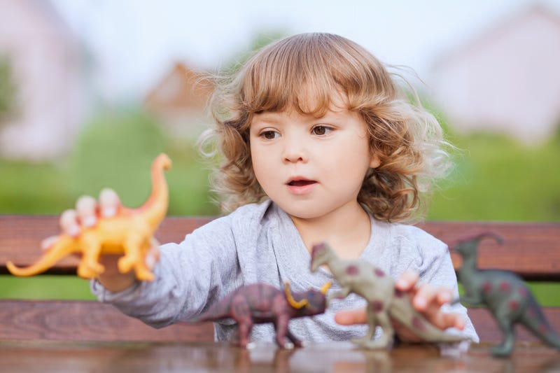 Child with toy dinosaurs