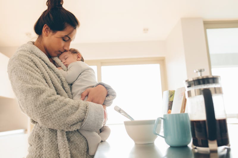 Woman holding sleeping baby.