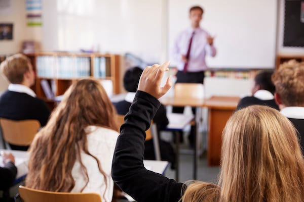 Student raising hand in classroom