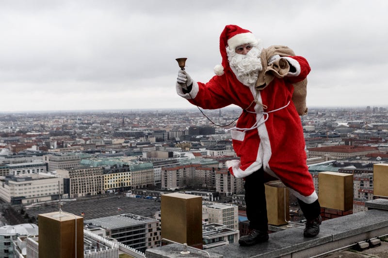 santa jingling bell with bag of gifts on rooftop