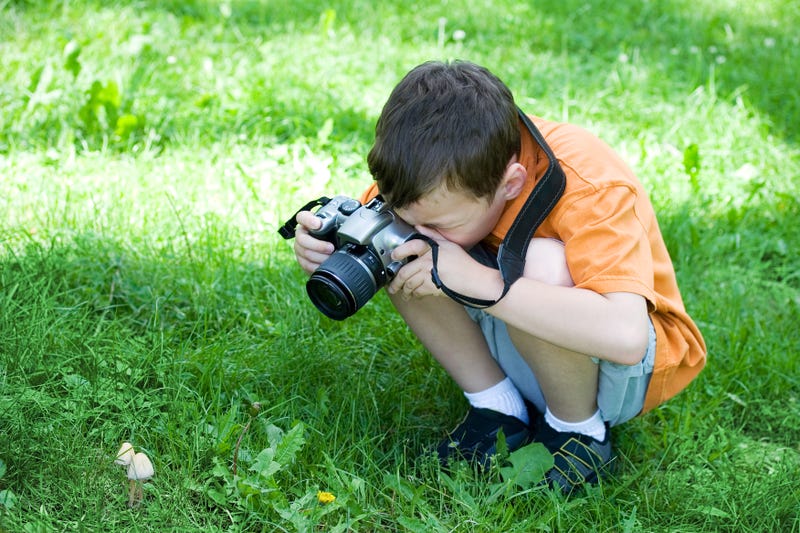 niño tomando fotos afuera