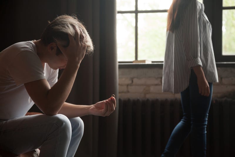 Frustrated man holding wedding ring, couple breaking up divorce concept