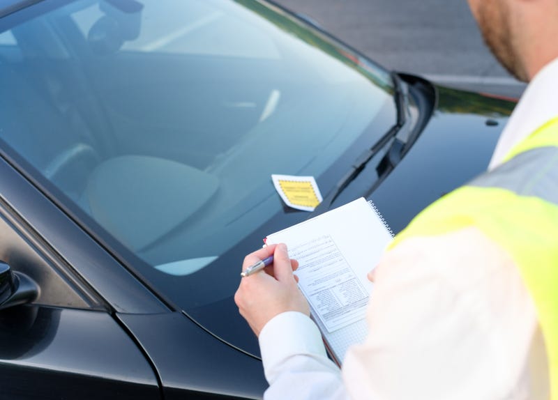 Person writing a parking ticket
