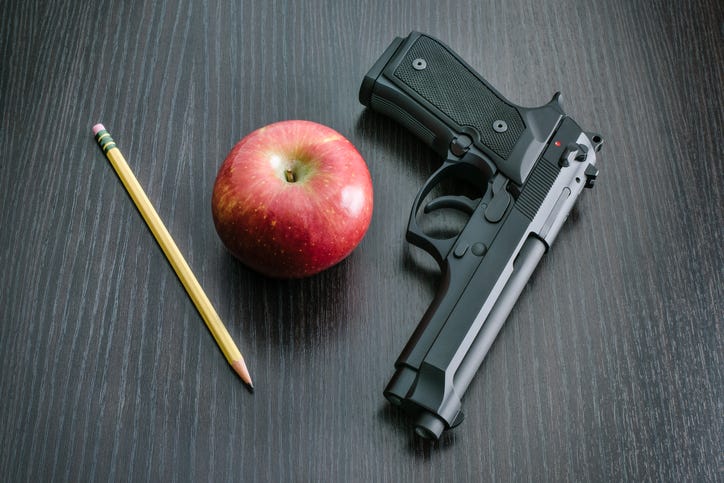 gun on a desk with an apple