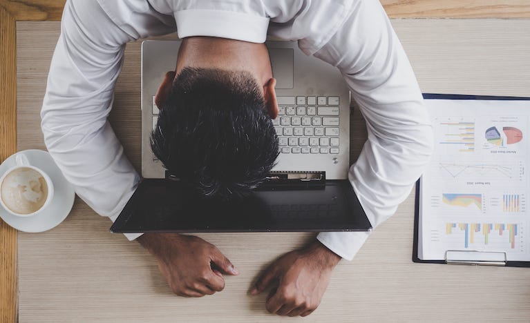 Man resting head on laptop