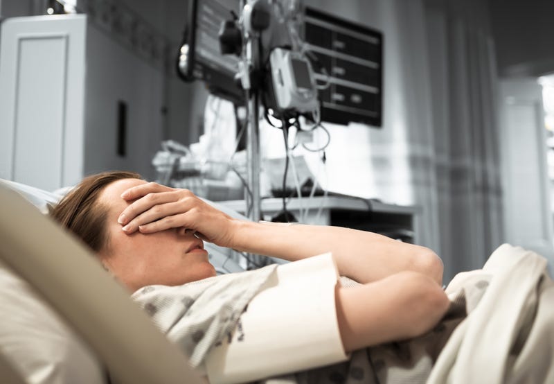 An upset woman lying in a hospital bed