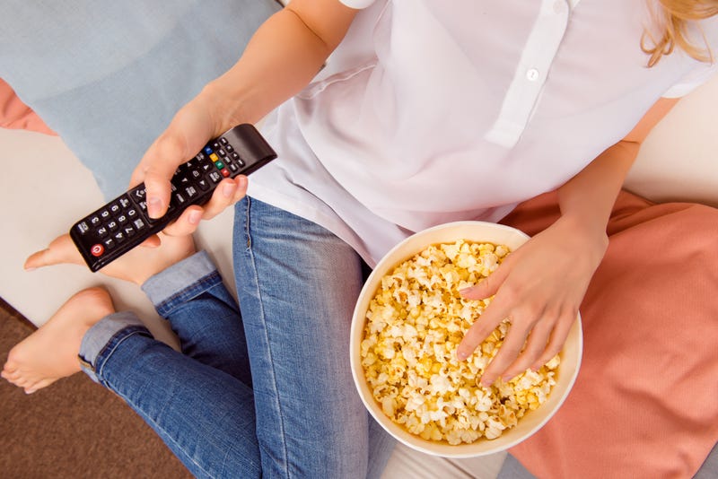 mujer viendo televisión y comiendo popcorn