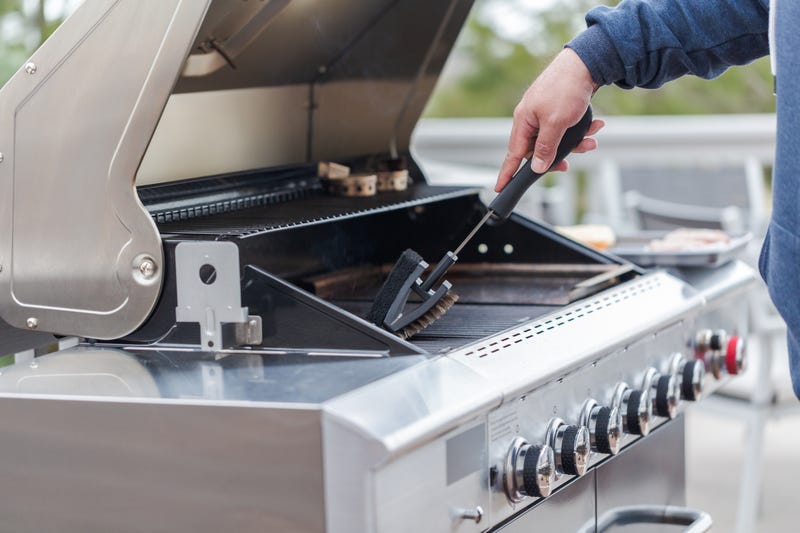 man cleaning grill barbecue
