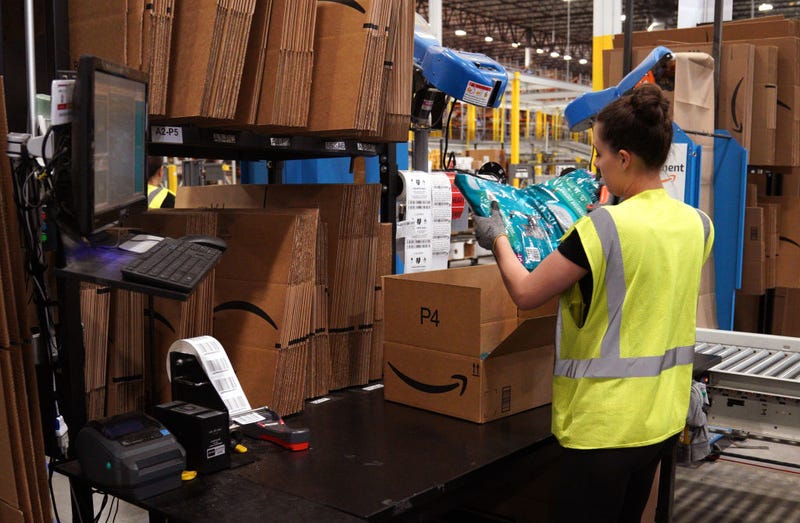 A worker packs cat food at the Amazon fullfillment center May 3, 2018 in Aurora, Colorado.