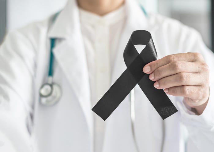 Black ribbon awareness in doctor's hand for Melanoma and skin cancer