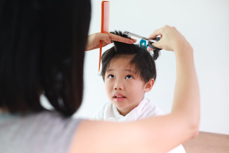 mom cutting son's hair