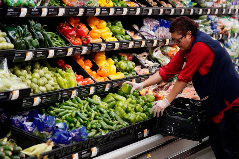 An associate restocks fresh vegetables at a Walmart Supercenter.