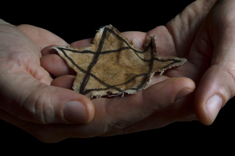 close up of hands holding a jewish star patch