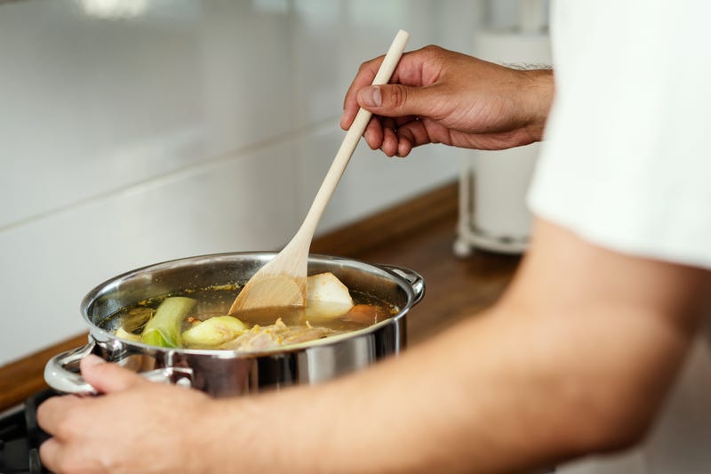 A man makes soup/stock