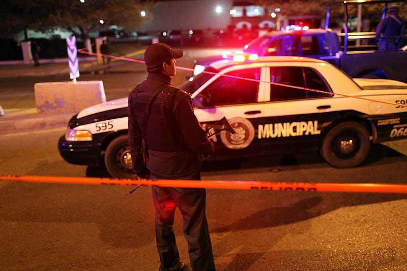Police gather at an early morning murder, one of numerous murders over a 24 hour period, on March 26, 2010 in Juarez, Mexico