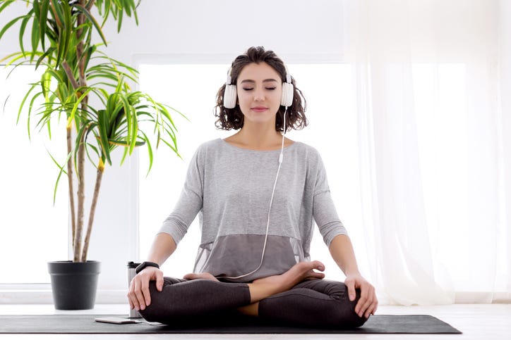 girl wearing headphones while doing yoga
