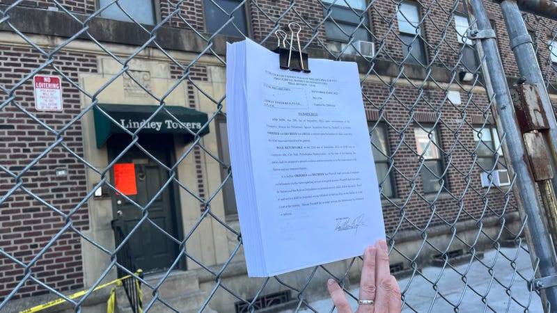 Legal filings from the City of Philadelphia were posted on the fence where an apartment building in Olney partially collapsed, before being removed by a building worker who would not identify himself.