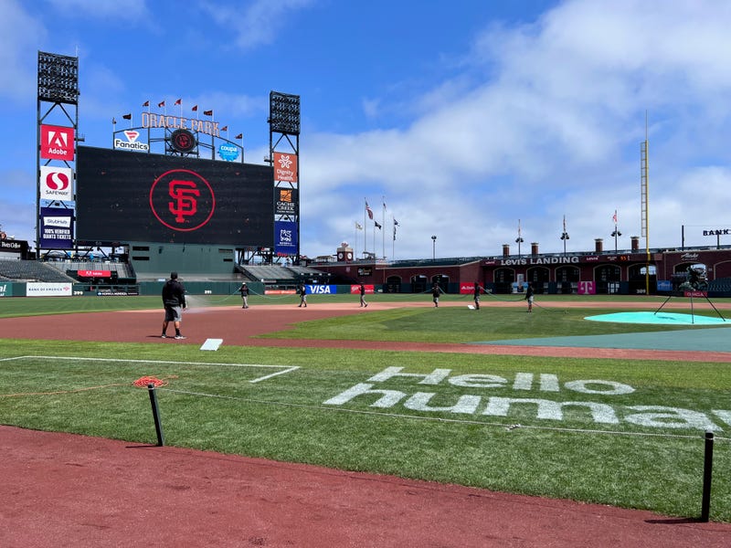 Oracle Park's grounds crew waters the infield.