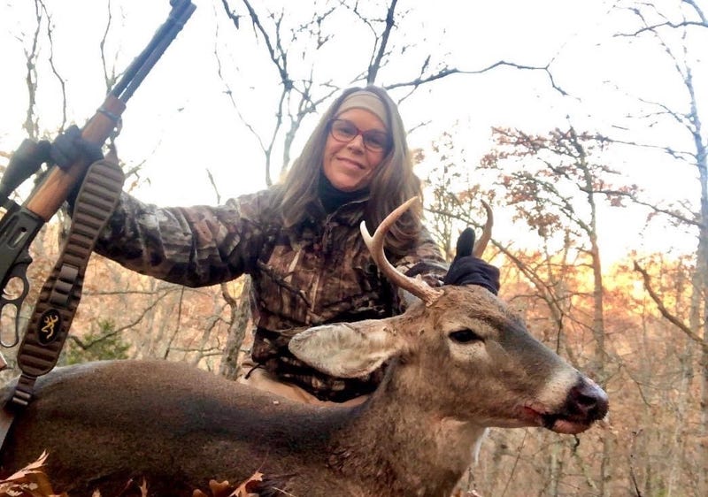 female hunter with dead deer