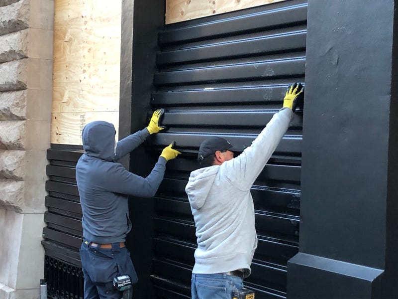 Workers board up Chanel in SoHo on Oct. 31, 2020.